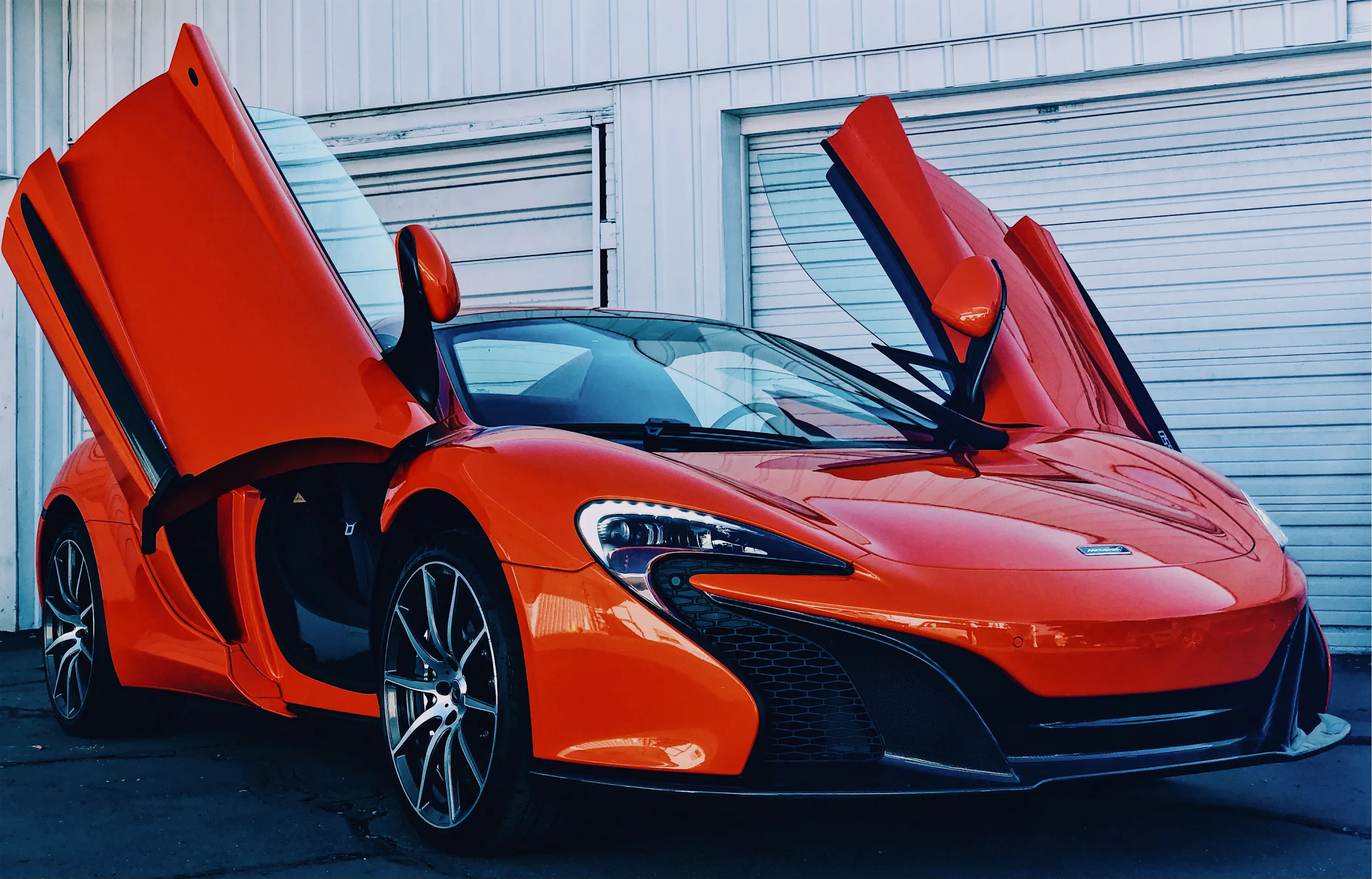 Red McLaren with doors up, protected with paint protection film at 4s Custom in Salt Lake City.