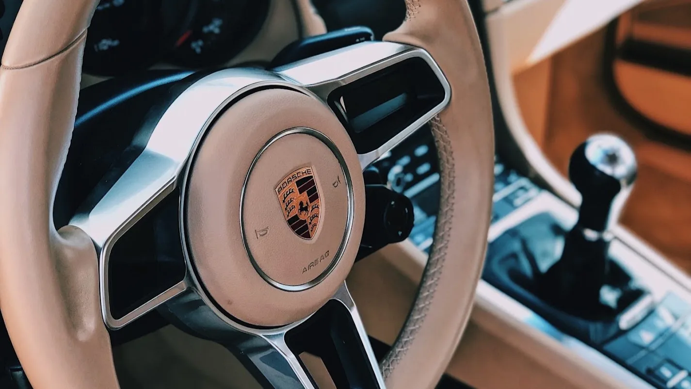 Close-up of a Porsche steering wheel and refined interior details after paint protection work.